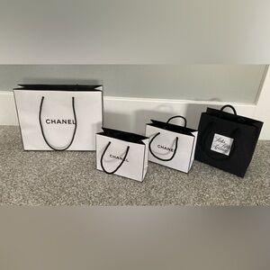 Chanel shopping bags (3) and one Saks Fifth Avenue